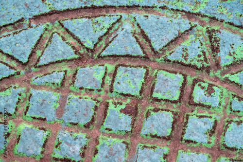 The texture of a fragment of a sewer manhole close up painted once upon a time with swamp color paint