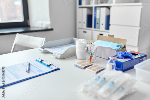 medicine, vaccination and healthcare concept - syringes, vaccine, protective medical gloves and plasters on table at hospital