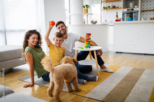 Canvas Print Happy family having fun time, playing together at home with dog