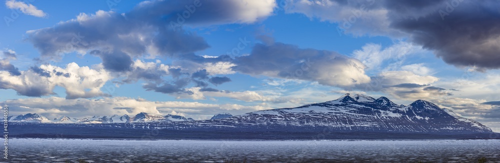 Panoramic image of a landscape in spring with the frozen reservoir Akkajaure and the Akka mountain range in Sarek National Park, Lapland, Sweden.