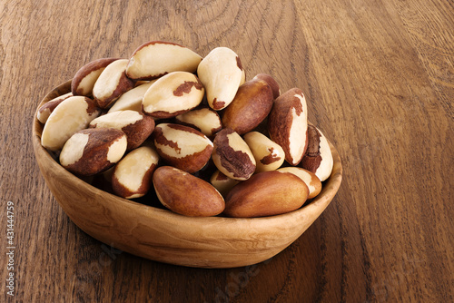 Brazil nuts in a bowl on a wooden background.
