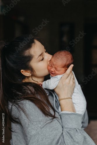 home photos of a newborn baby in the arms of mother. Selective focus, noise effect