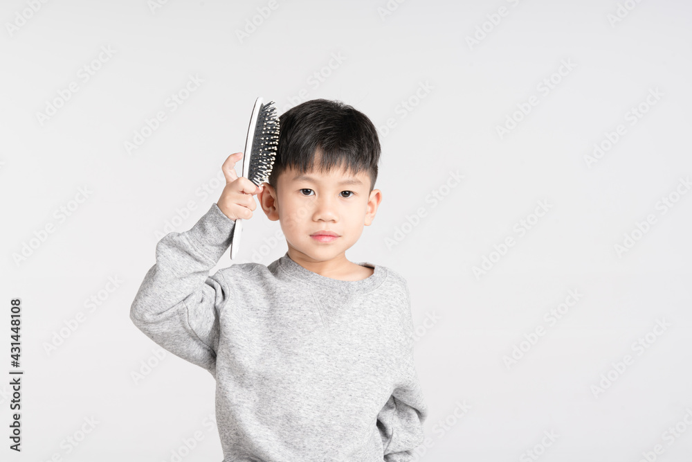 Asian boy holding brush comb for dressing hairstyle Asian boy holding brush comb for dressing hairstyle