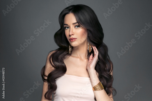 Beautiful woman with long hair, shine and curly, beauty girl female over darl gray background photo