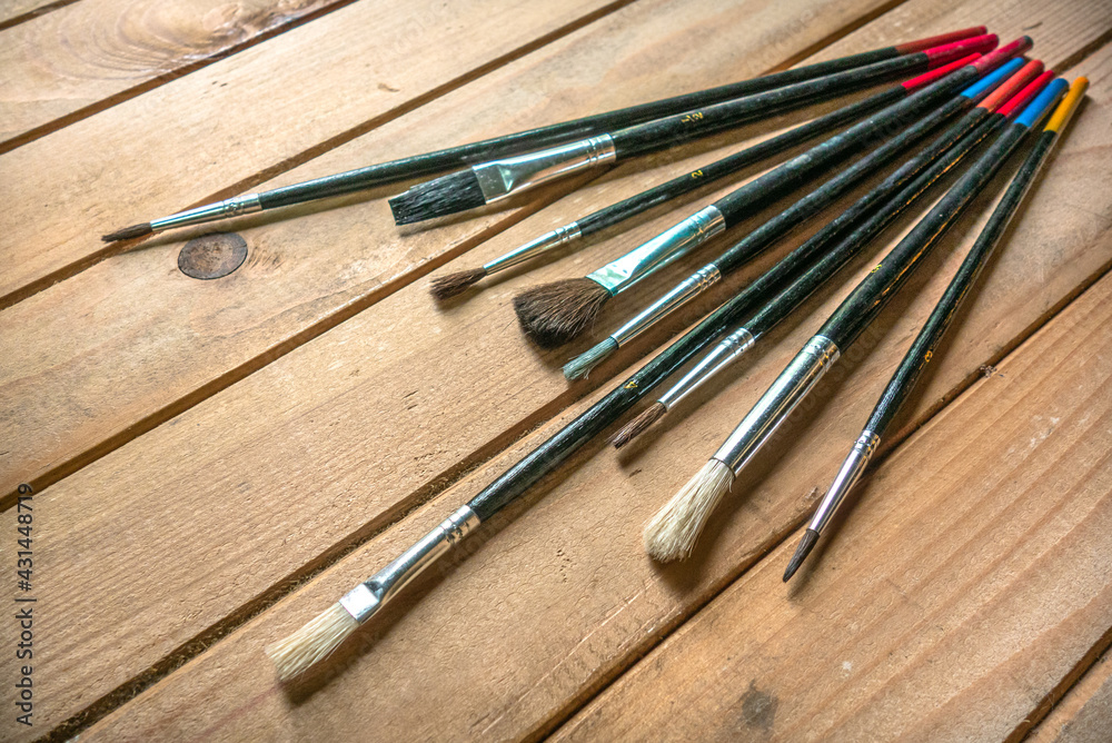 Black brushes of different pile lengths on a wooden table Black brushes of different pile lengths on a wooden table