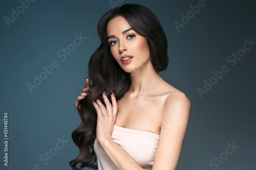 Beautiful woman with long hair, shine and curly, beauty girl female over darl gray background