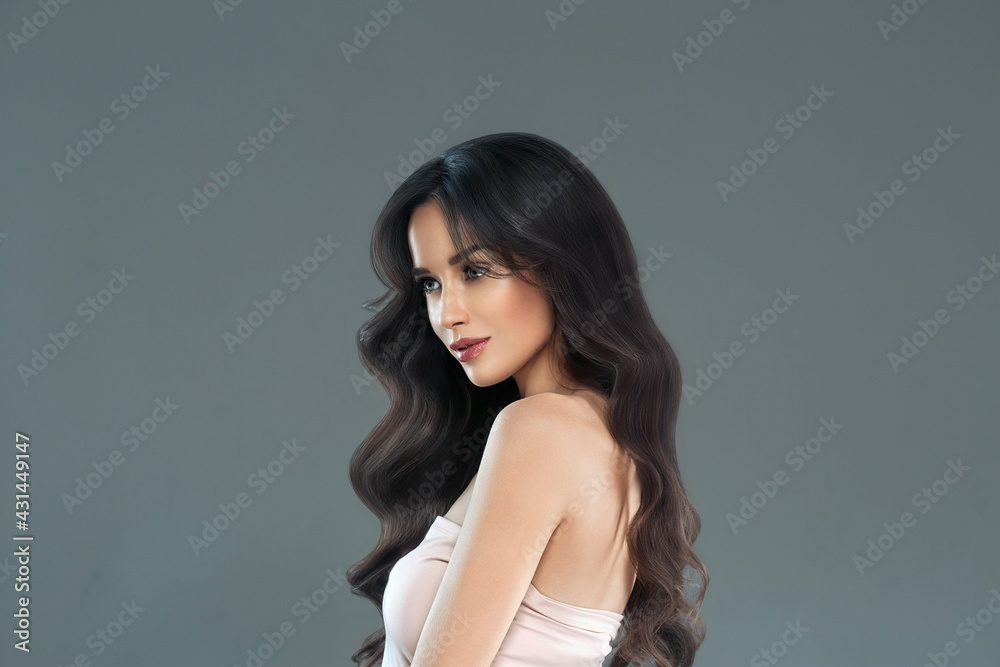 Naklejka premium Beautiful woman with long hair, shine and curly, beauty girl female over darl gray background