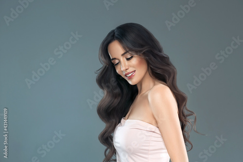Beautiful woman with long hair, shine and curly, beauty girl female over darl gray background