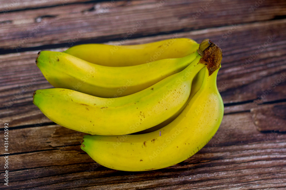 Canarian bananas on a wooden table. Variety of bananas grown in the Canary Islands in Spain Canarian bananas on a wooden table. Variety of bananas grown in the Canary Islands in Spain