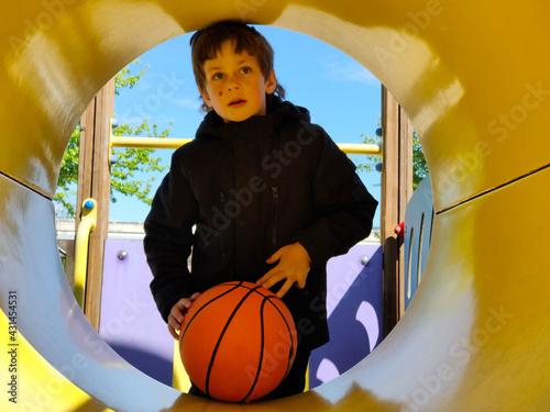 boy with autism playing on the swings with the ball