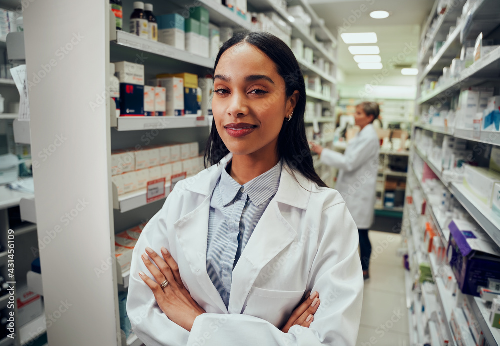 Young pharmacist with crossed arms looking at camera in drugstore Young pharmacist with crossed arms looking at camera in drugstore