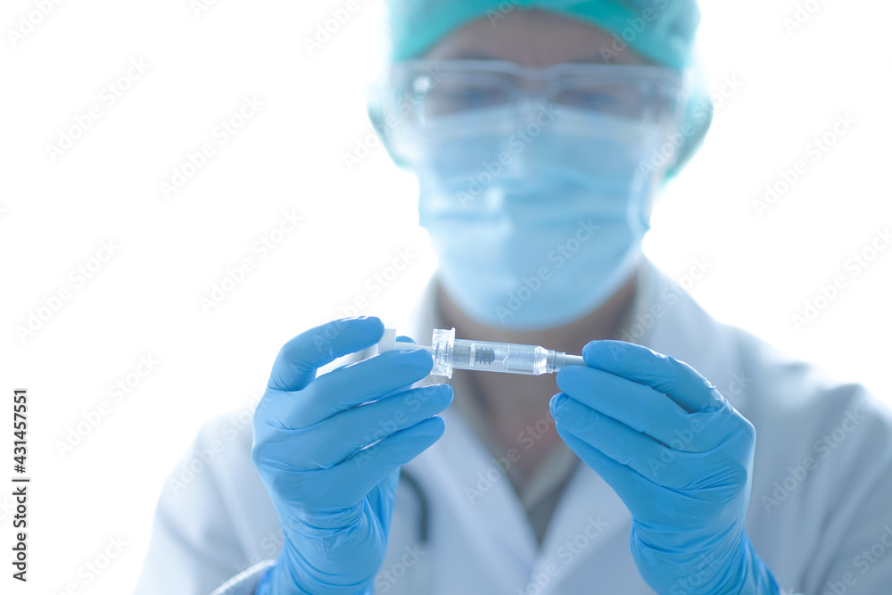COVID-19 vaccine in researcher's hands, the doctor holds syringe and bottle with a vaccine for coronavirus cure. soft focus. COVID-19 vaccine in researcher's hands, the doctor holds syringe and bottle with a vaccine for coronavirus cure. soft focus.