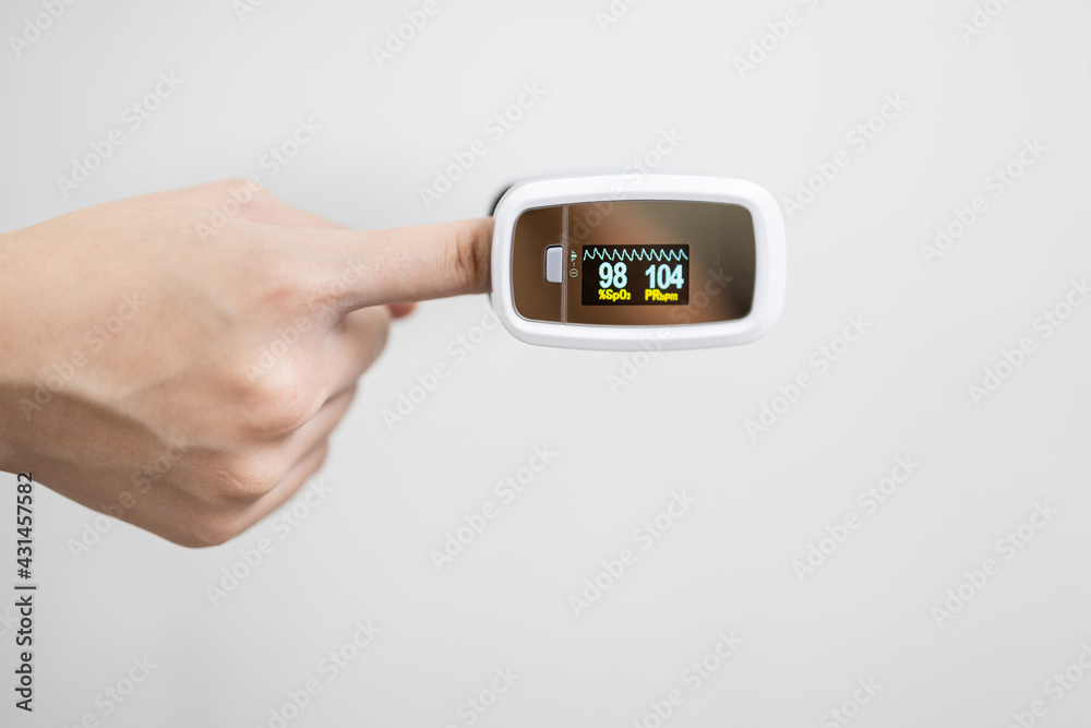 Fingertip pulse oximeter on the finger of child girl measuring heart