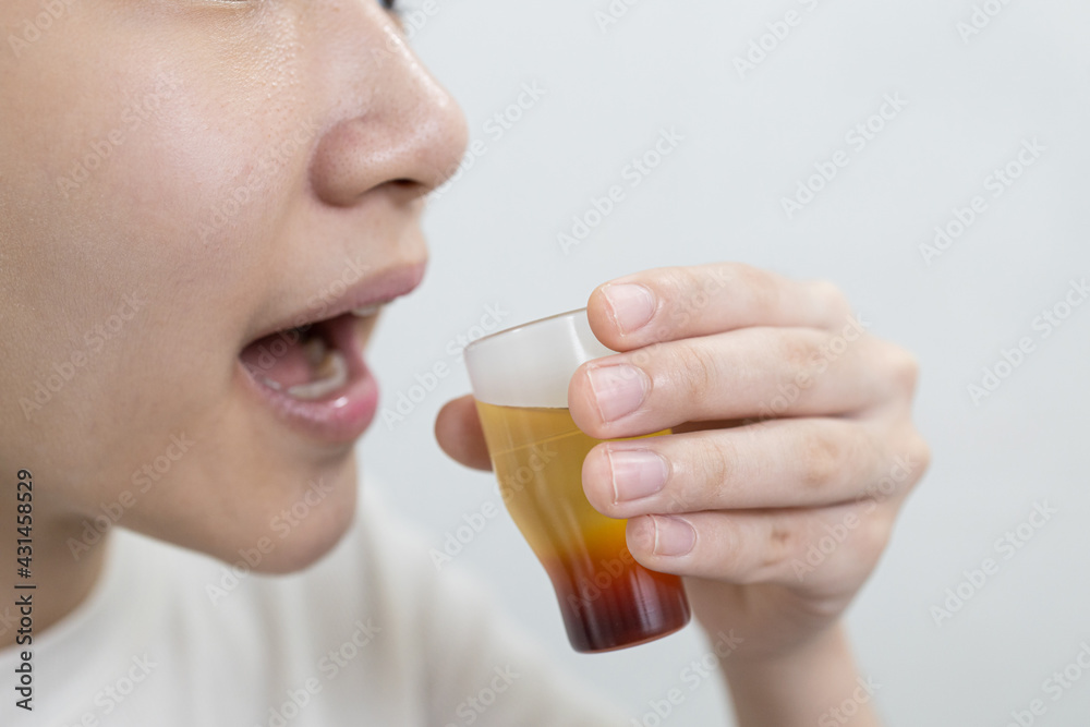 Asian child girl gargling with an antiseptic,protect against the Coronavirus COVID-19 in throat,disinfection prevention of oral wound infections or bad breath,halitosis disease,gingivitis,tonsillitis