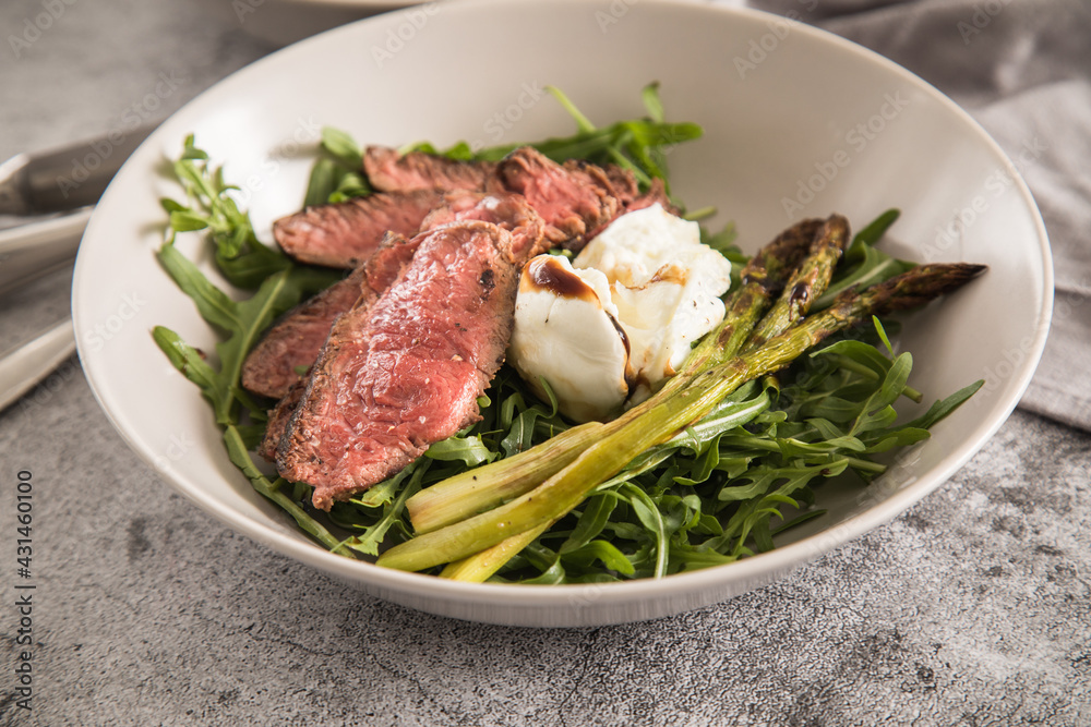 Gerösteter grüner Spargel mit medium rare Rinder Steak Streifen, Rucola, Büffel Mozzarella, Olivenöl und Balsamico in Schale mit Leinen Serviette, Besteck und rustikal Stein Hintergrund
Gerösteter grüner Spargel mit medium rare Rinder Steak Streifen, Rucola, Büffel Mozzarella, Olivenöl und Balsamico in Schale mit Leinen Serviette, Besteck und rustikal Stein Hintergrund