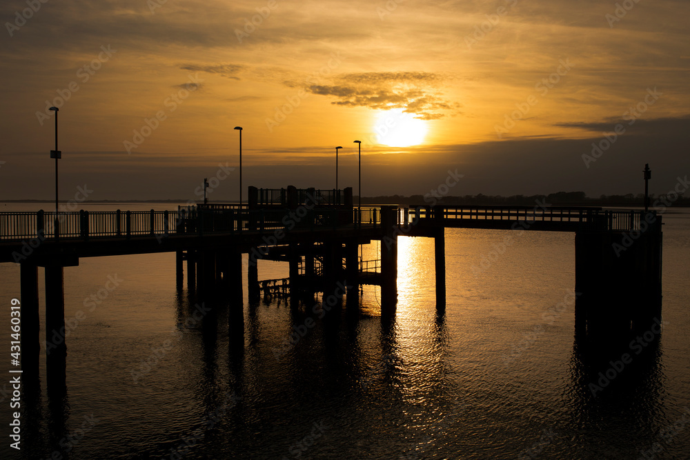 Caernarfon pier, on Victoria Dock, reflected in sea at sunset. Holiday resort destination in Wales