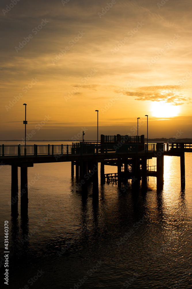 Caernarfon pier, on Victoria Dock, reflected in sea at sunset. Holiday resort destination in Wales