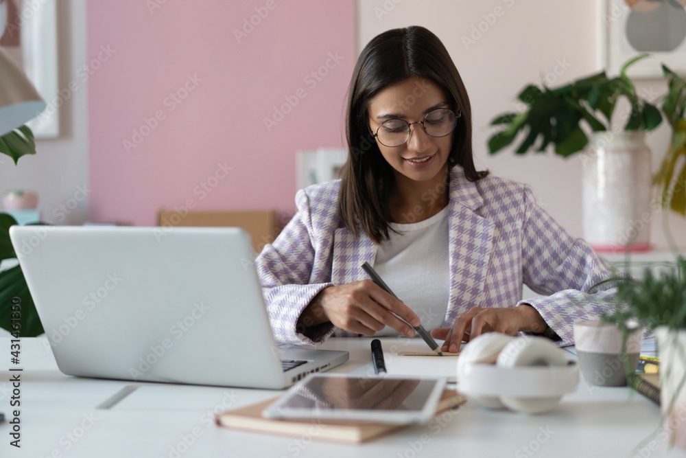Indian mixed-race beautiful businesswoman working on a new project on her workplace using laptop at the office. Indian mixed-race beautiful businesswoman working on a new project on her workplace using laptop at the office.