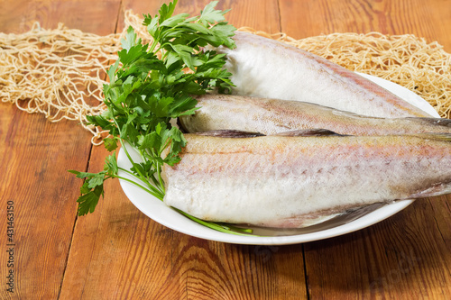 Alaska pollock carcasses on old rustic table with fishing net photo