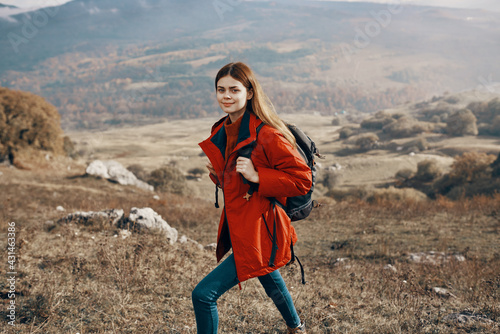 a traveler in a jacket jeans and boots climbs the mountains in nature landscape