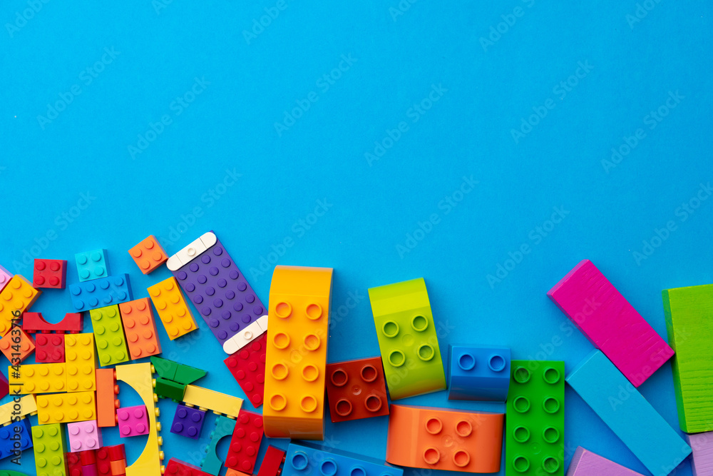 Obraz premium Multicolored pieces of toy constructor on blue background