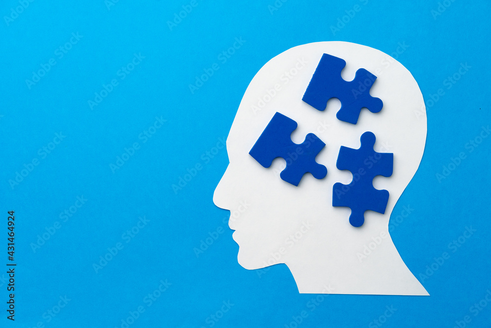 Papercut head with jigsaw puzzle pieces on blue background Papercut head with jigsaw puzzle pieces on blue background
