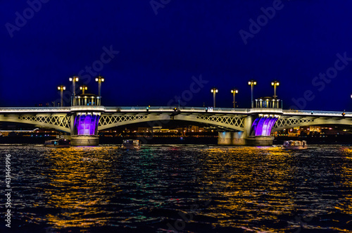 Fotografie A bridge spanning the Neva river, illuminated by lanterns and floodlights on a w