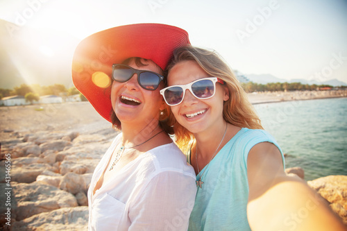 Happy people, Mother And Adult Daughter Making Selfe On The Beach Traveling Together photo