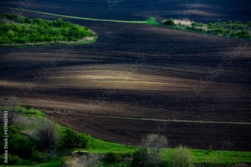 Texture of brown agricultural soil. Beautiful sunrise on the farm. The Farm in the Moldova, Europe. Freshly plowed spring field for planting vegetable seeds. © romeof
