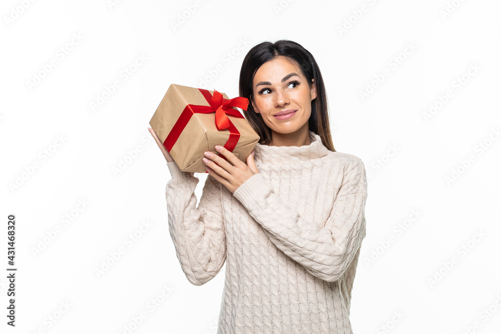 Happy pretty young woman holding gift box over gray background Happy pretty young woman holding gift box over gray background