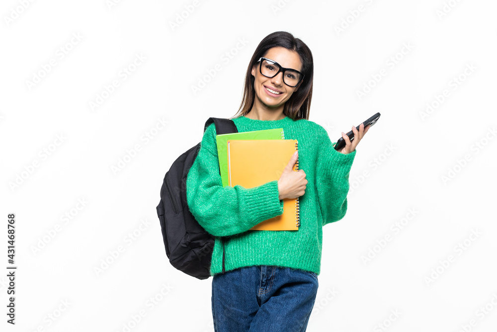 Young woman university student with backpack and books sending a sms on cell phone, isolated on white background Young woman university student with backpack and books sending a sms on cell phone, isolated on white background