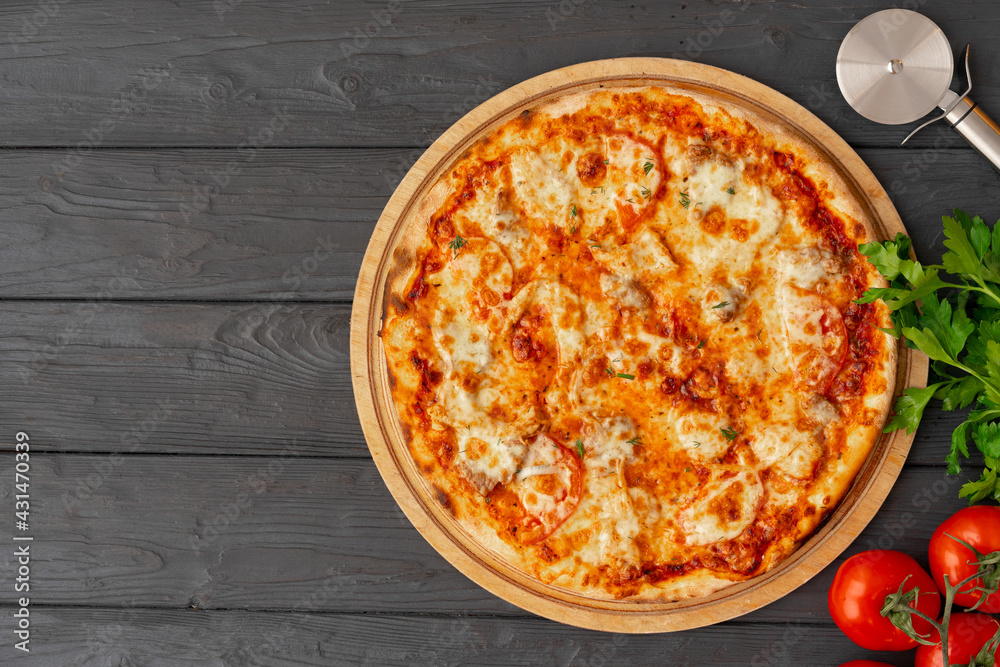 Tasty pizza on black wooden background top view Tasty pizza on black wooden background top view