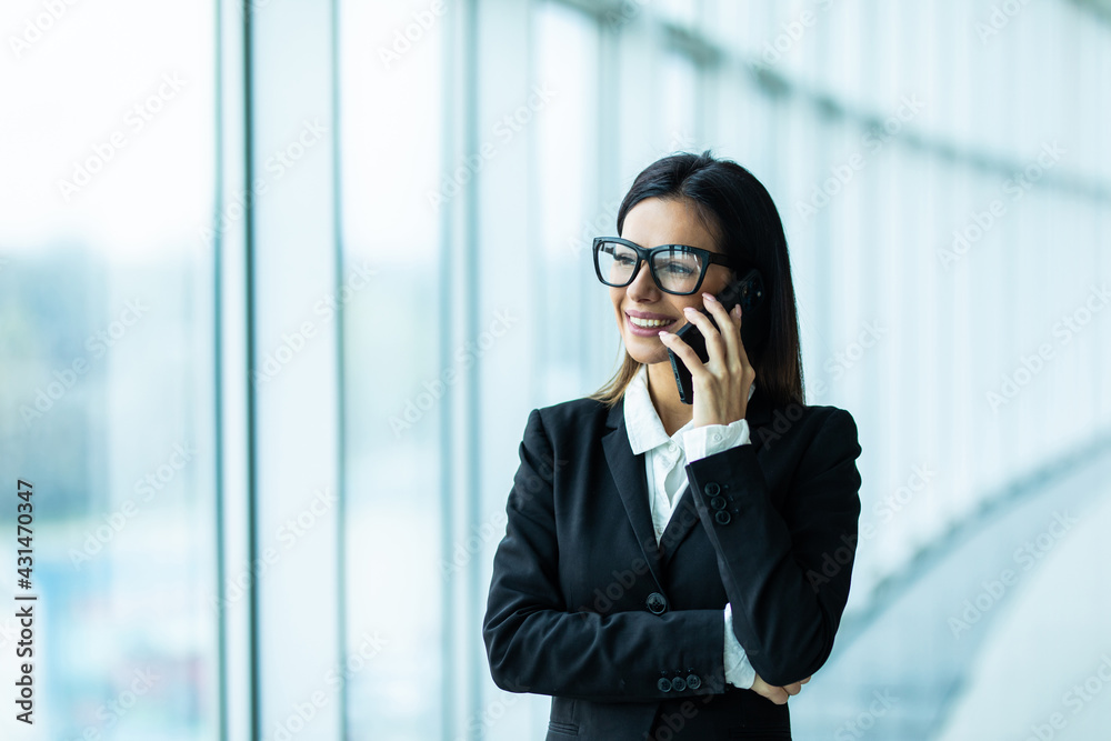 Businesswoman Making Phone Call Standing By Office Window Businesswoman Making Phone Call Standing By Office Window