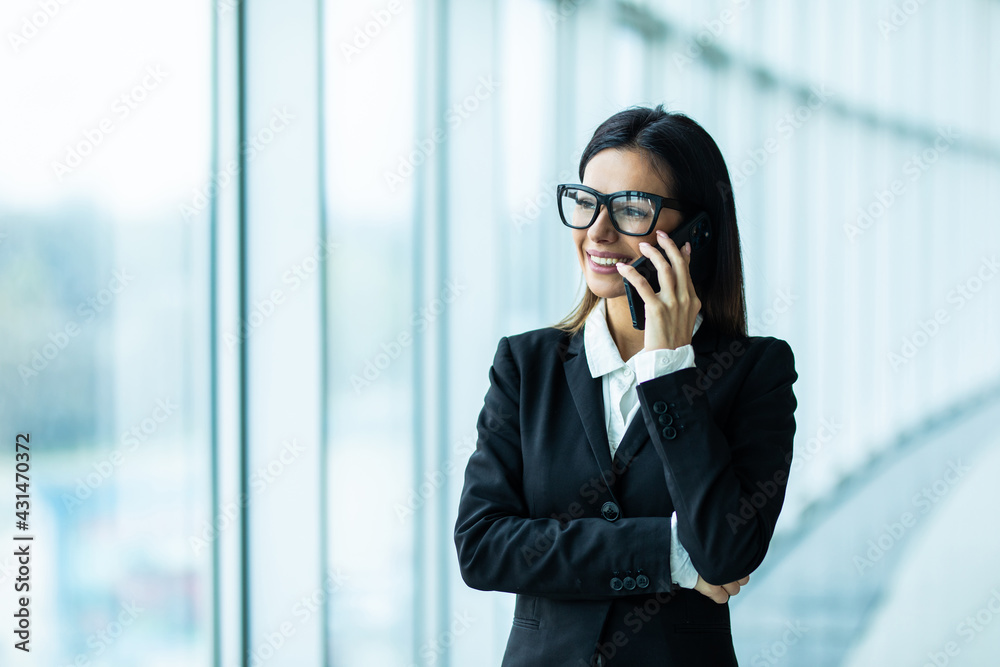Young woman talking on phone in modern office Young woman talking on phone in modern office