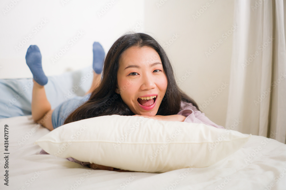 lifestyle portrait of young and beautiful Asian woman at home - attractive and happy Japanese girl gesturing playful and cheerful on bed smiling relaxed lifestyle portrait of young and beautiful Asian woman at home - attractive and happy Japanese girl gesturing playful and cheerful on bed smiling relaxed