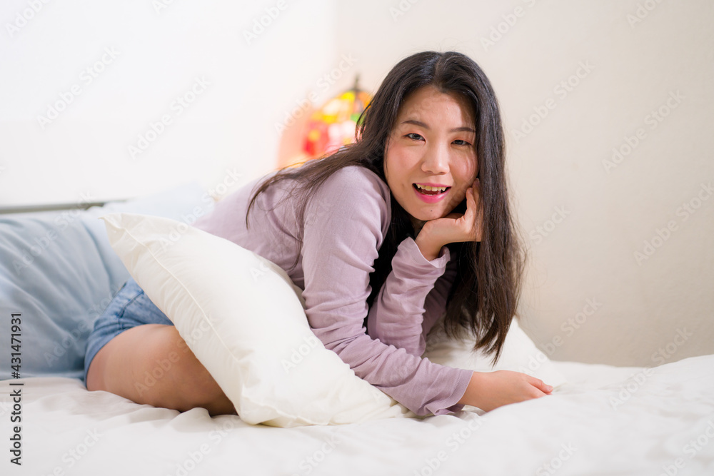 lifestyle portrait of young and beautiful Asian woman at home - attractive and happy Korean girl looking relaxed and cheerful on bed lifestyle portrait of young and beautiful Asian woman at home - attractive and happy Korean girl looking relaxed and cheerful on bed