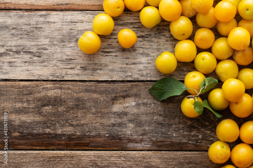 Yellow plum on a wooden rustic background with copy space.