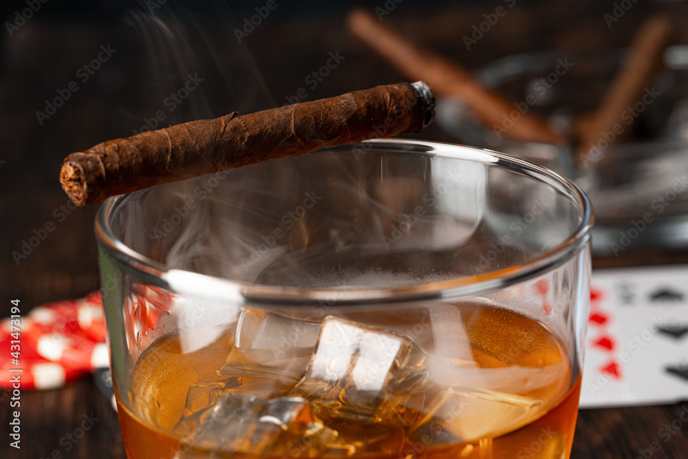 Cuban cigar, whiskey glass and chips on table - obrazy, fototapety, plakaty 