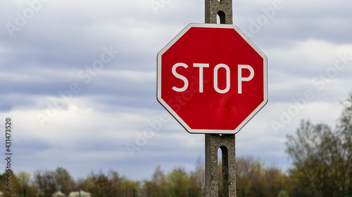 Znak stop, znak zakazu B-20 zawieszony na betonowym słupie
