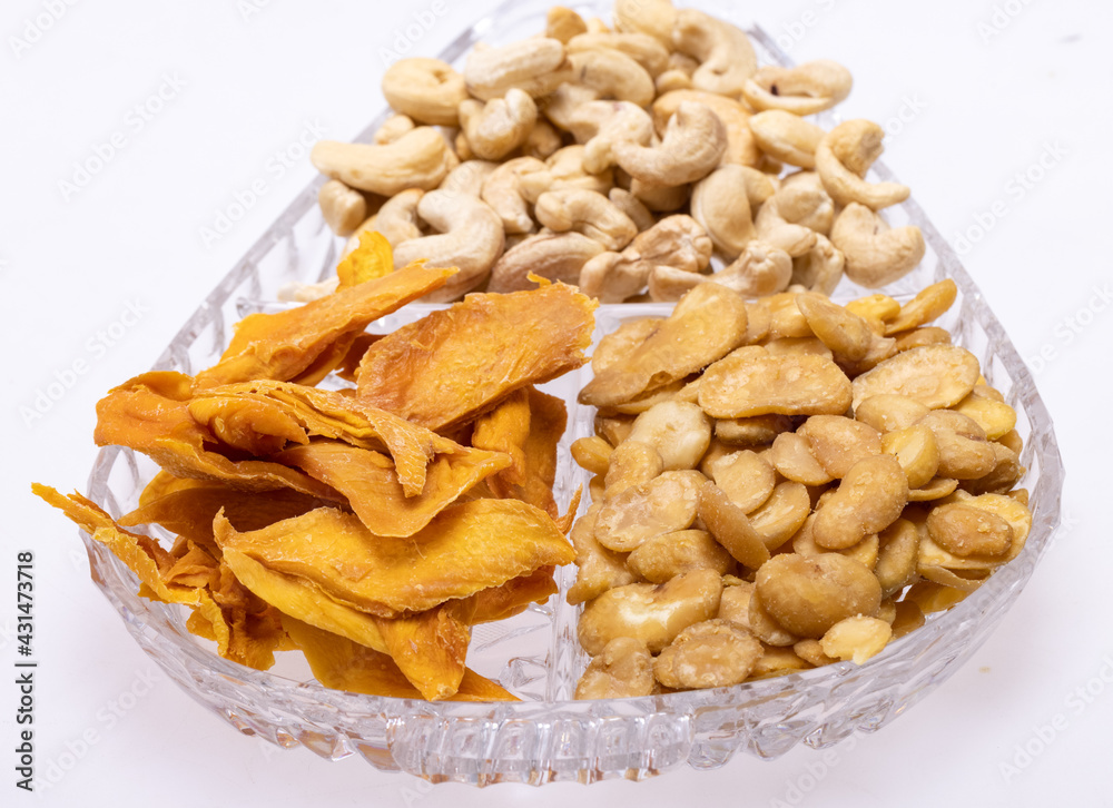 Roasted and salted fava beans, cashew nuts and dried mango slices for a healthy vegan and vegetarian diet snack. High in protein, vitamins, dietary fibre and nutrients Roasted and salted fava beans, cashew nuts and dried mango slices for a healthy vegan and vegetarian diet snack. High in protein, vitamins, dietary fibre and nutrients