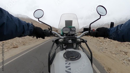 Pov of a man riding a himalyan bike in the mountains of ladakh. photo