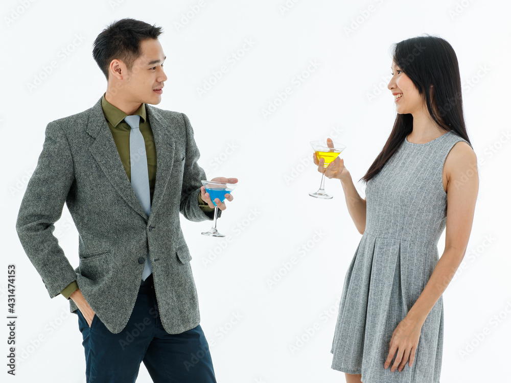 Young man and woman wearing smart casual style smile standing looking at each other hands holding cocktail glass feel relaxing. Business meeting, event, party concept. Young man and woman wearing smart casual style smile standing looking at each other hands holding cocktail glass feel relaxing. Business meeting, event, party concept.