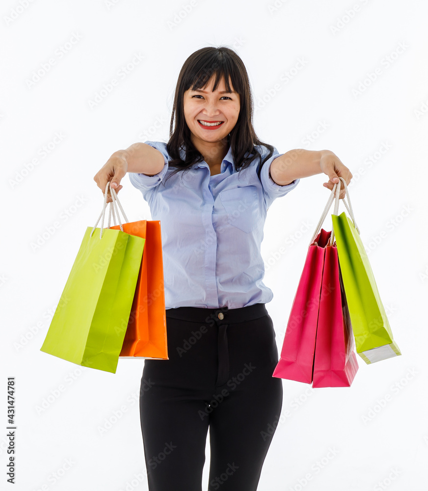 Young lady standing in studio show colorful shopping bags in her hands with big smile like she happy to be shopper. Concept buyer, consumerism, emotions, lifestyle, purchase, sale, discount,shopaholic