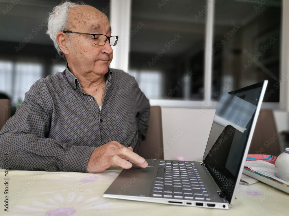 Serious older man using laptop close up, looking at screen, watching video or surfing internet, focused mature male using online clinic service or searching insurance information, medical app Serious older man using laptop close up, looking at screen, watching video or surfing internet, focused mature male using online clinic service or searching insurance information, medical app