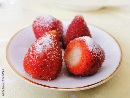 fresh ripe strawberries in a simple white bowl, on wood table