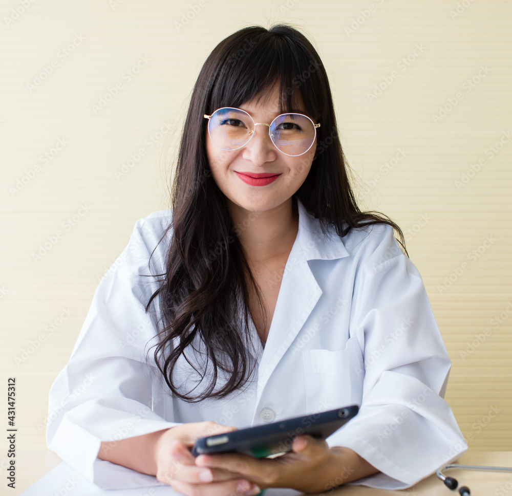 Asian beautiful lady long black hair nice eyes red lips in white medical suit. Sit smiling look at camera. Her smile help to cheerful people. Looks trustworthy, professional, friendly. Asian beautiful lady long black hair nice eyes red lips in white medical suit. Sit smiling look at camera. Her smile help to cheerful people. Looks trustworthy, professional, friendly.