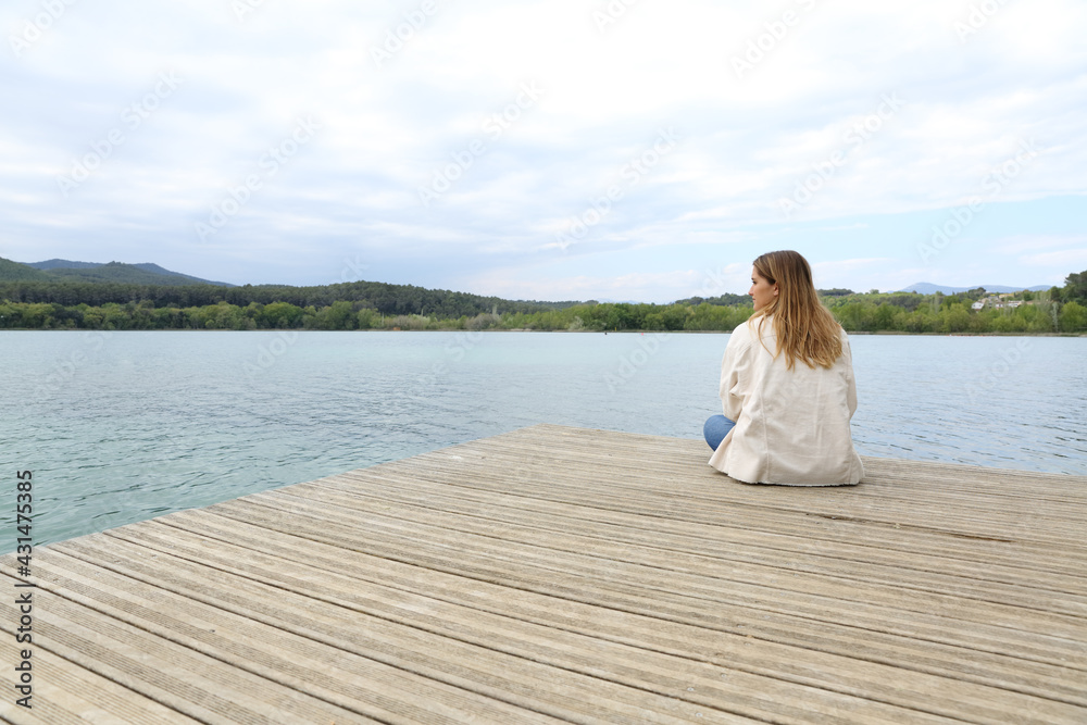 Woman resting contemplating views in a lake