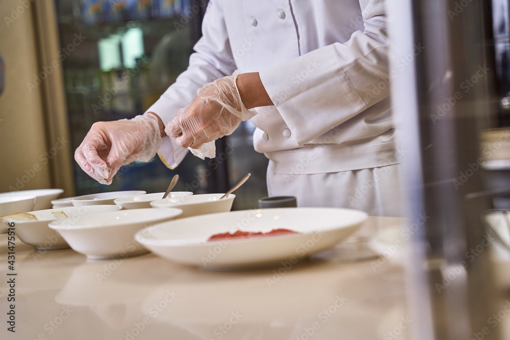 Chef adding spices to dishes in many bowls Chef adding spices to dishes in many bowls