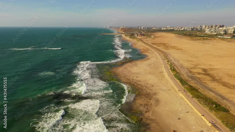 Aerial Shot Of Waves Splashing On Shore At Beach Against Sky, Drone Flying Forward Over People At Park In City By Sea On Sunny Day - Tel Aviv, Israel Aerial Shot Of Waves Splashing On Shore At Beach Against Sky, Drone Flying Forward Over People At Park In City By Sea On Sunny Day - Tel Aviv, Israel