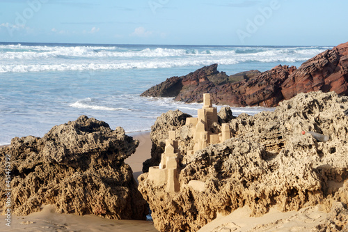 sand castle with many details built on rock at sandy beach © mikesch112